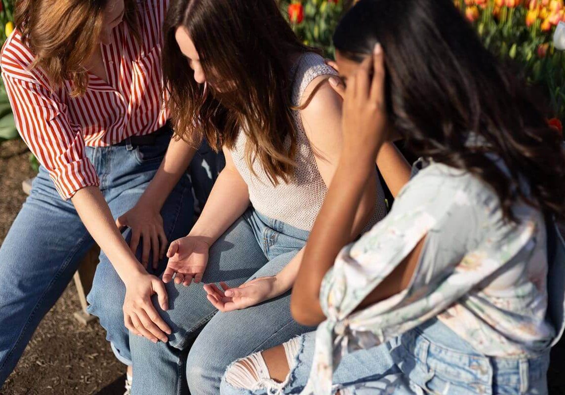 Girls praying while laying on hands